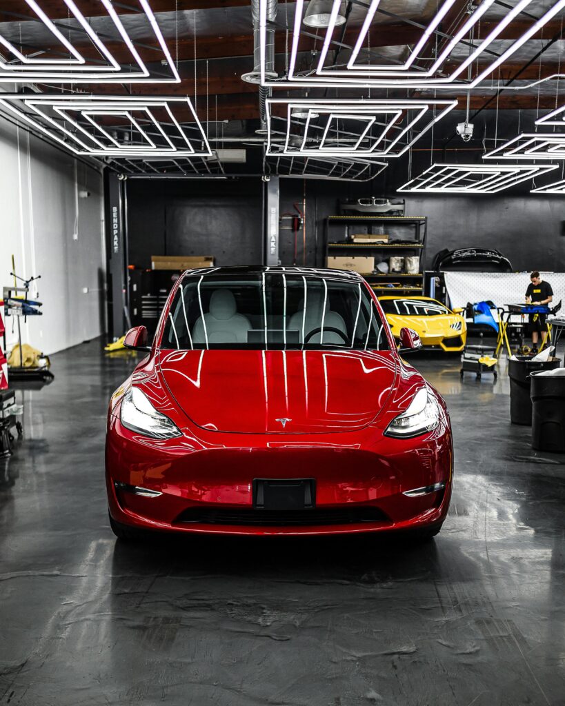 A luxury electric car parked indoors with striking LED lighting in a modern garage.
